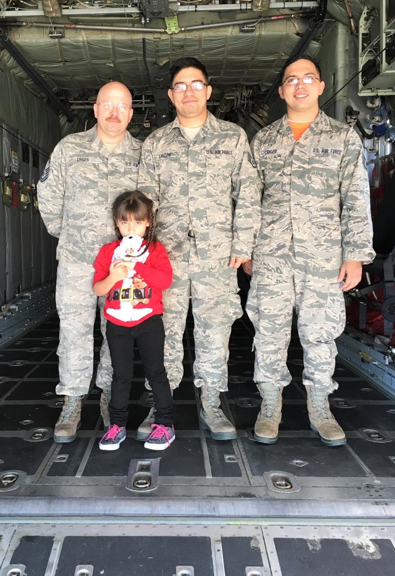 Airmen poise for a family photo in a C-130