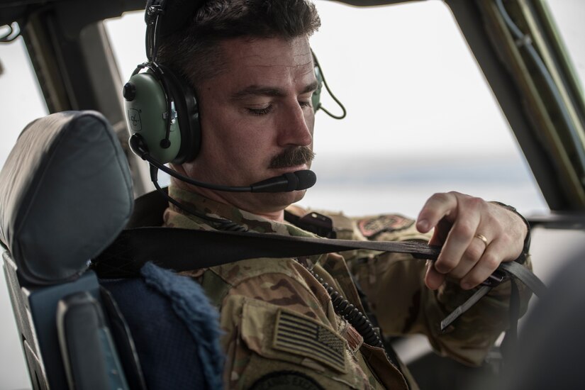 Maj. Jonathan Mahan, a C-17 Globemaster III pilot assigned to the 14th Airlift Squadron, fastens his seatbelt as he assumes control of the aircraft May 14, 2019, during flight training operations over the Gulf of Mexico.
