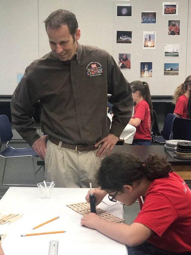 Transatlantic Middle East District civil engineer Ted Upson, aka Gator, discusses design strategies with students from Sacred Heart Academy during their week-long adventure at STARBASE Academy Winchester.