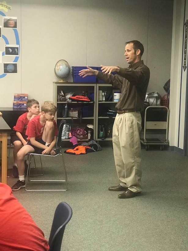 Transatlantic Middle East District civil engineer Ted Upson discusses results of the weight bearing test done on the bridges built by the students at STARBASE.