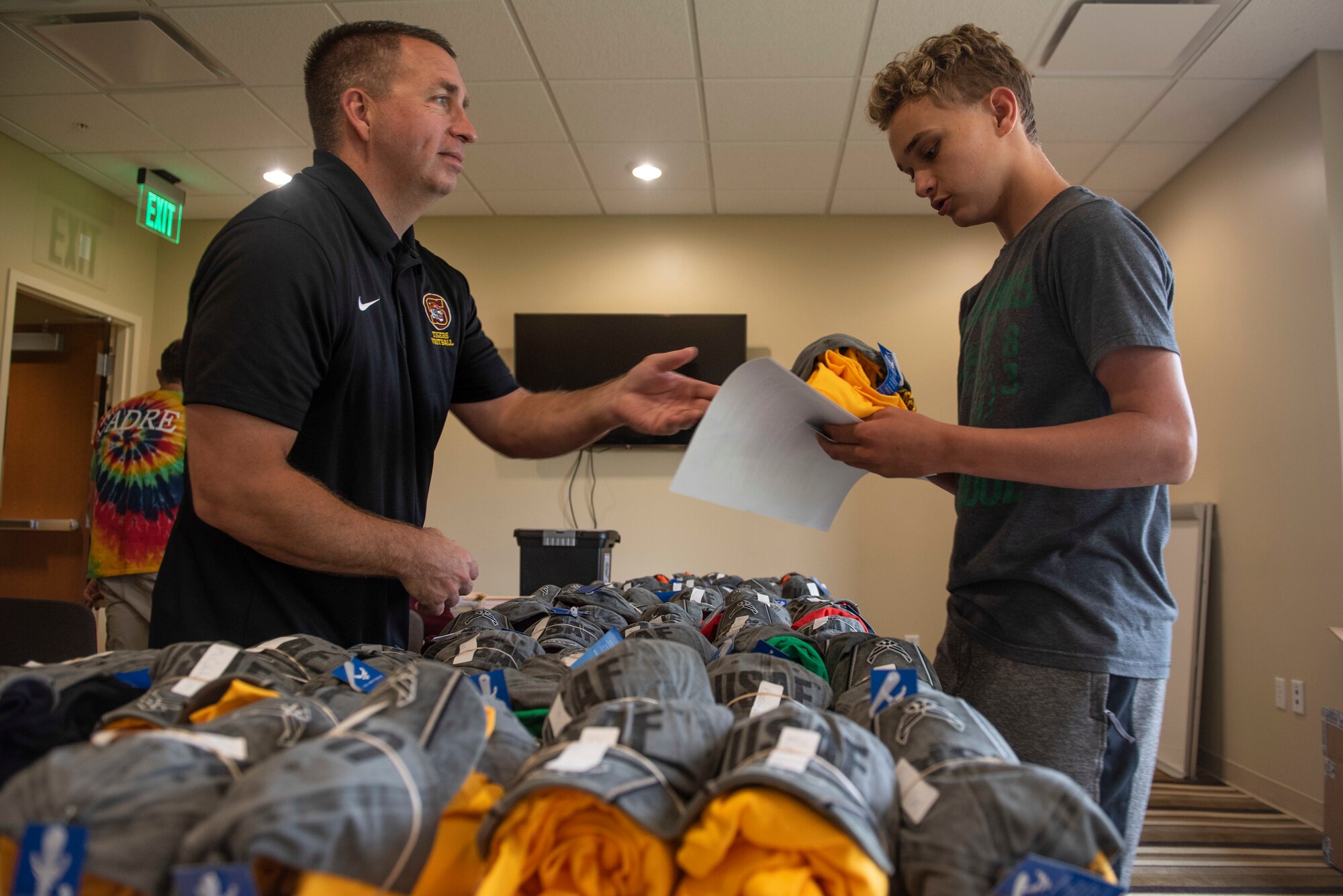 Retired U.S. Air Force Lt. Col. Benji Jackson, passes out hats and flight shirts to registering Air Force Junior ROTC cadets, June 2, 2019, at Scott Air Force Base, Ill. Approximately 120 cadets from throughout the Midwest arrived at Scott AFB to participate in the Cadet Leadership Course. (U.S. Air Force photo by Senior Airman Daniel Garcia)
