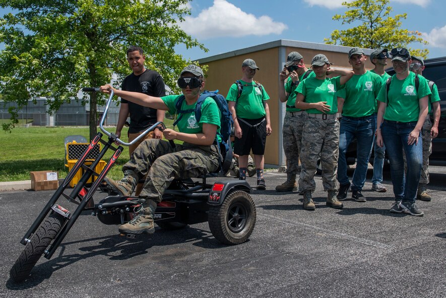U.S. Air Force Airman 1st Class Edwin Lozada, 375th Security Forces Squadron admin specialist, gives Air Force Junior ROTC cadets participating in the Cadet Leadership Course a turn on the Drunk Busters bicycle June 5, 2019 at Scott Air Force Base, Ill. Equipped with a pair of drunk goggles, each cadet experienced a simulated drunk driving scenario to learn about how difficult it can be to navigate while under the influence. (U.S. Air Force photo by Senior Airman Daniel Garcia)