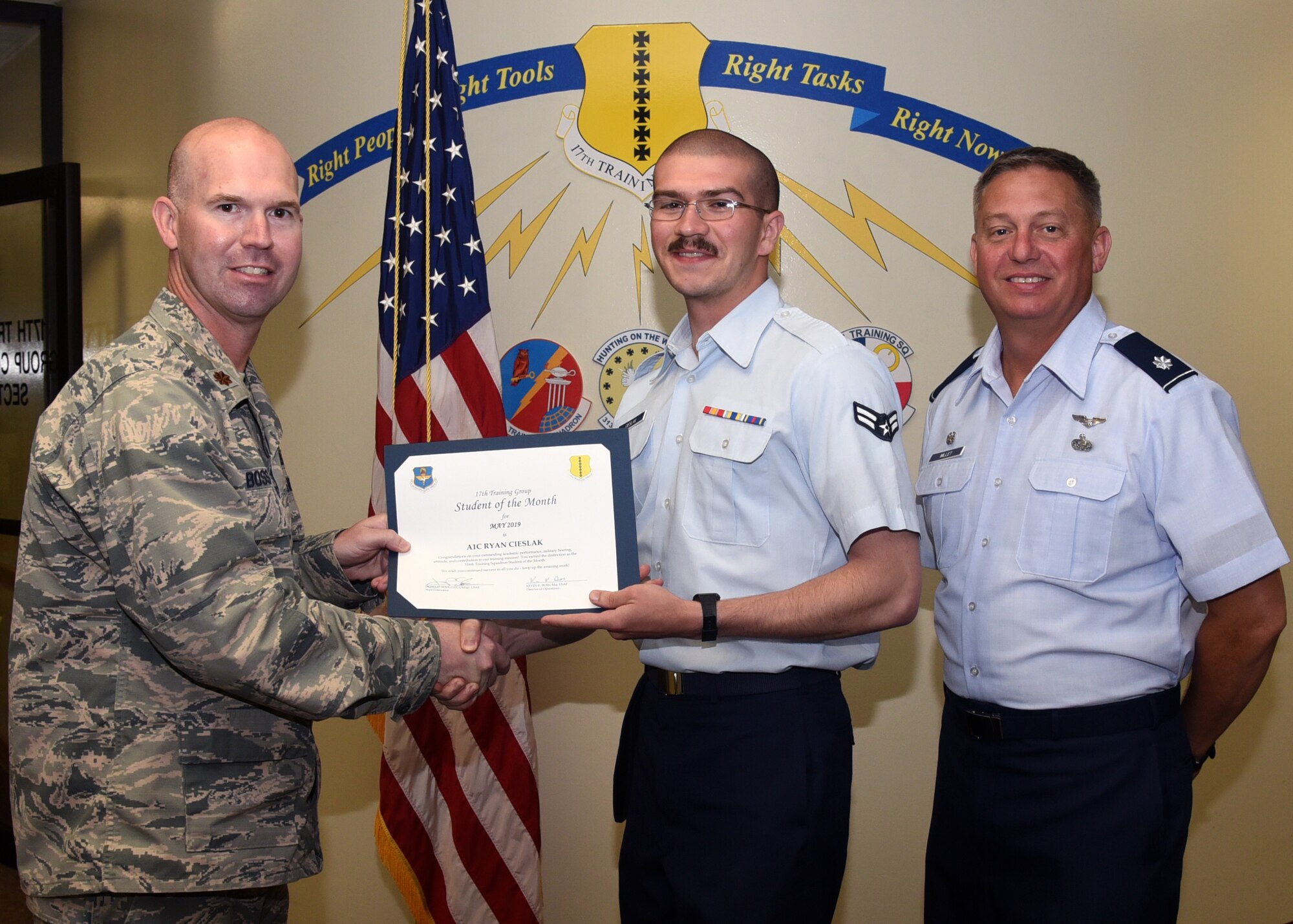 U.S. Air Force Maj. Kevin Boss, 17th Training Group director of operations, presents the 316th Training Squadron Student of the Month award to Airman 1st Class Ryan Cieslak, 316th TRS student, at the Brandenburg Hall on Goodfellow Air Force Base, Texas, June 7, 2019. The 316th TRS’s mission is to conduct U.S. Air Force, U.S. Army, U.S. Marine Corps, U.S. Navy and U.S. Coast Guard cryptologic, human intelligence and military training. (U.S. Air Force photo by Airman 1st Abbey Rieves/Released)