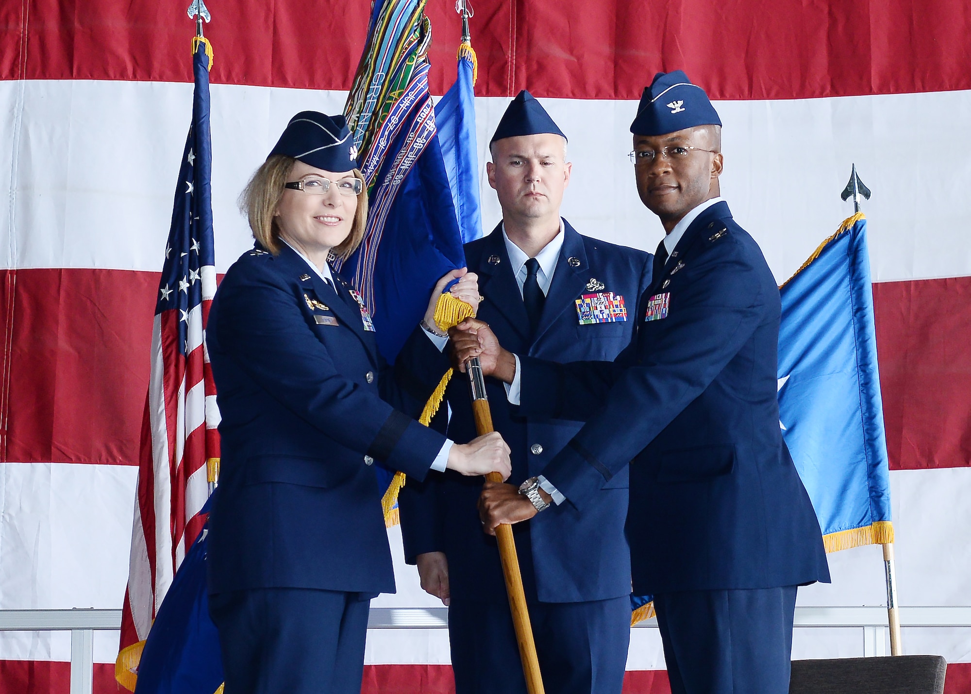 U.S. Air Force Maj. Gen. May O'Brien, 25th Air Force commander, passes the 55th Wing guidon to Col. Gavin Marks,  during the 55th Wing Change of Command ceremony June 14, 2019, inisde Dock 1 of the Bennie Davis Maintenance Facility at Offutt Air Force Base, Nebraska. Marks assumed command from Col. Michael H. Manion, who departs Offutt AFB for the Pentagon.