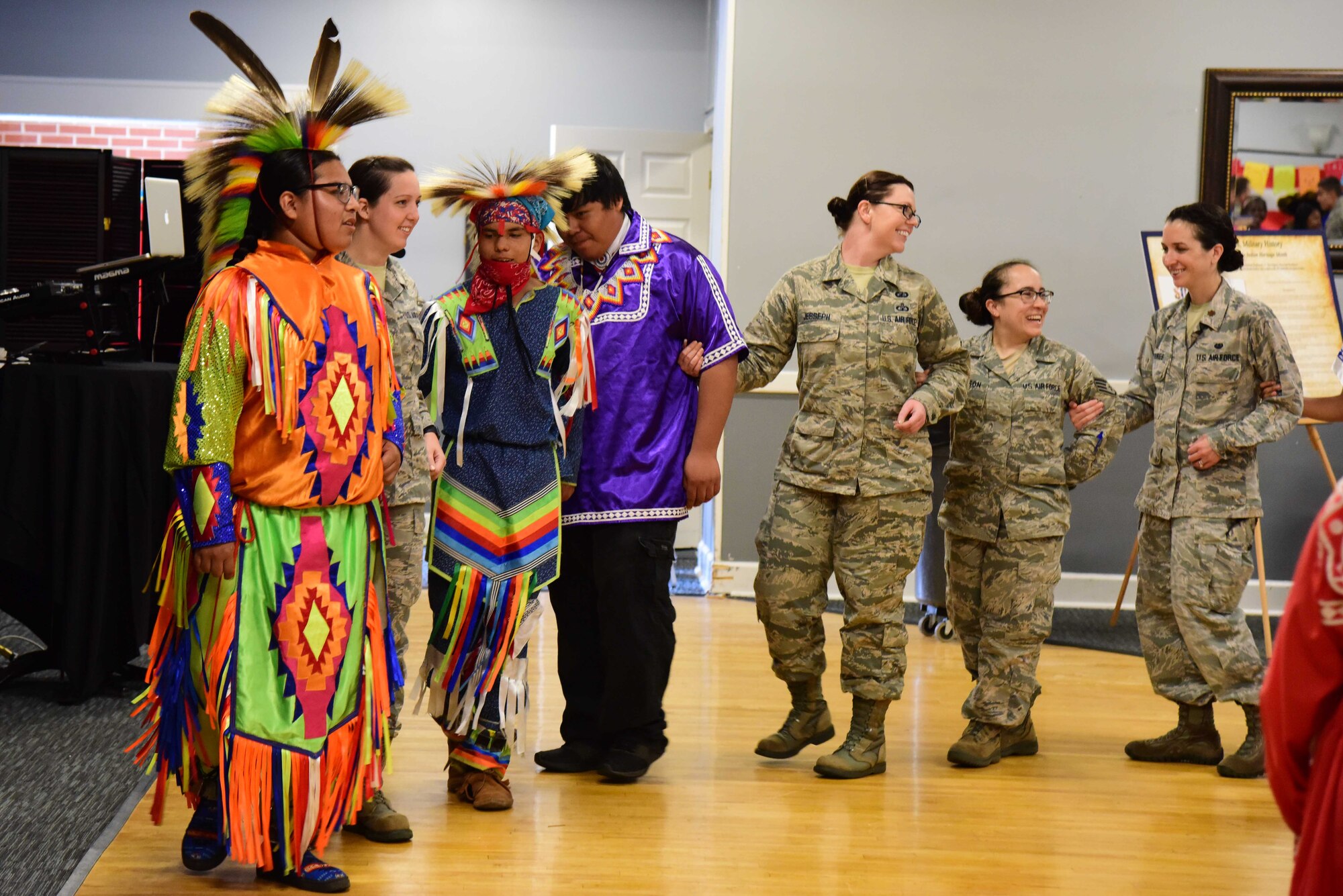 Choctaw dancers joined by military members lock arms for the festivities at Diversity Day, June 7, 2019, on Columbus Air Force Base, Miss. The Choctaw Dancers asked the attendees to get involved in a few of their traditional dances to get the community involved in their traditions. (U.S. Air Force photo by Elizabeth Owens)