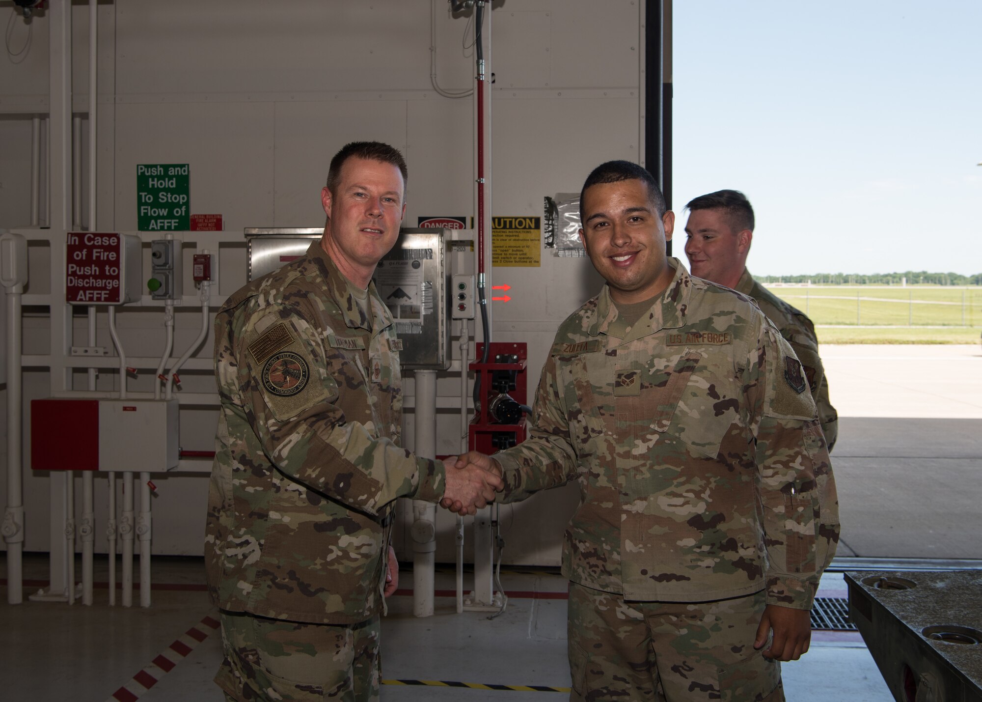 Chief Master Sgt. Charles R. Hoffman, the command chief of Air Force Global Strike Command from Barksdale Air Force Base, Louisiana, shakes hands with Senior Airman Jeisson Zuleta-Cespedes, a munitions handling technician with the 509th Munitions Squadron, on June 11, 2019, at Whiteman Air Force Base, Missouri. Hoffman coined a number of Airmen during his immersion tour of Whiteman AFB, including Zuleta, who coined Hoffman as well. (U.S. Air Force Photo by Airman 1st Class Parker J. McCauley)