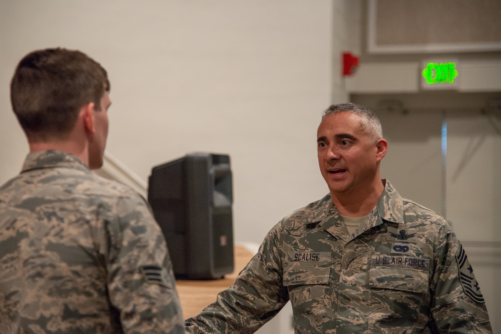 Chief Master Sgt. Kahn Scalise, the 302nd Airlift Wing command chief, speaks with Senior Airman Andrew Peeples, a 302nd Maintenance Squadron ammunition specialist, in the base theater June 1, 2019 at Peterson Air Force Base, Colorado.
