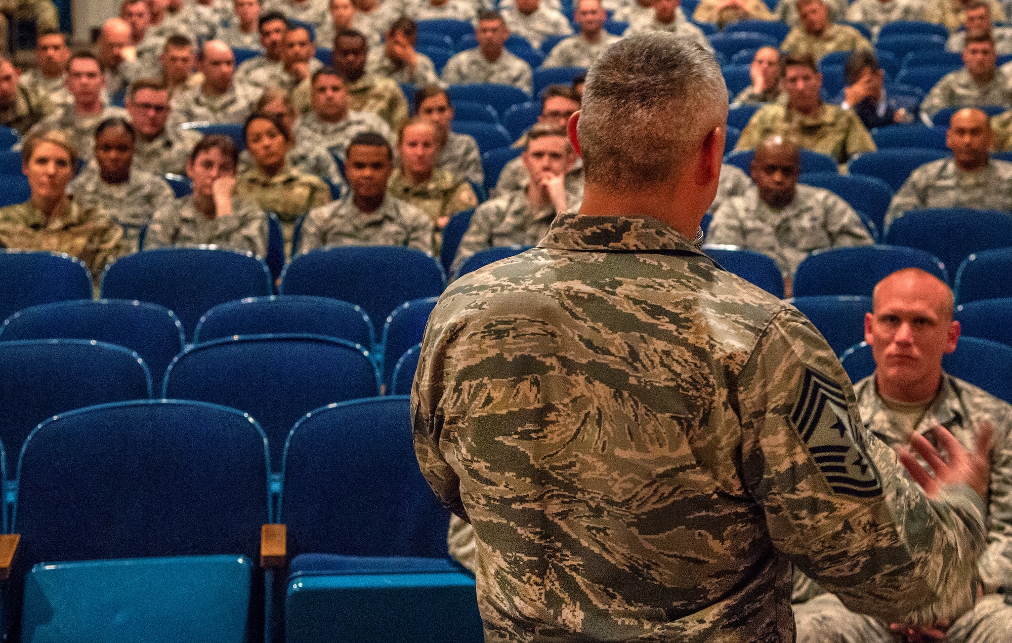 Chief Master Sgt. Kahn Scalise, the 302nd Airlift Wing command chief, addresses noncommissioned officers during an enlisted town hall meeting in the base theater June 1, 2019 at Peterson Air Force Base, Colorado.