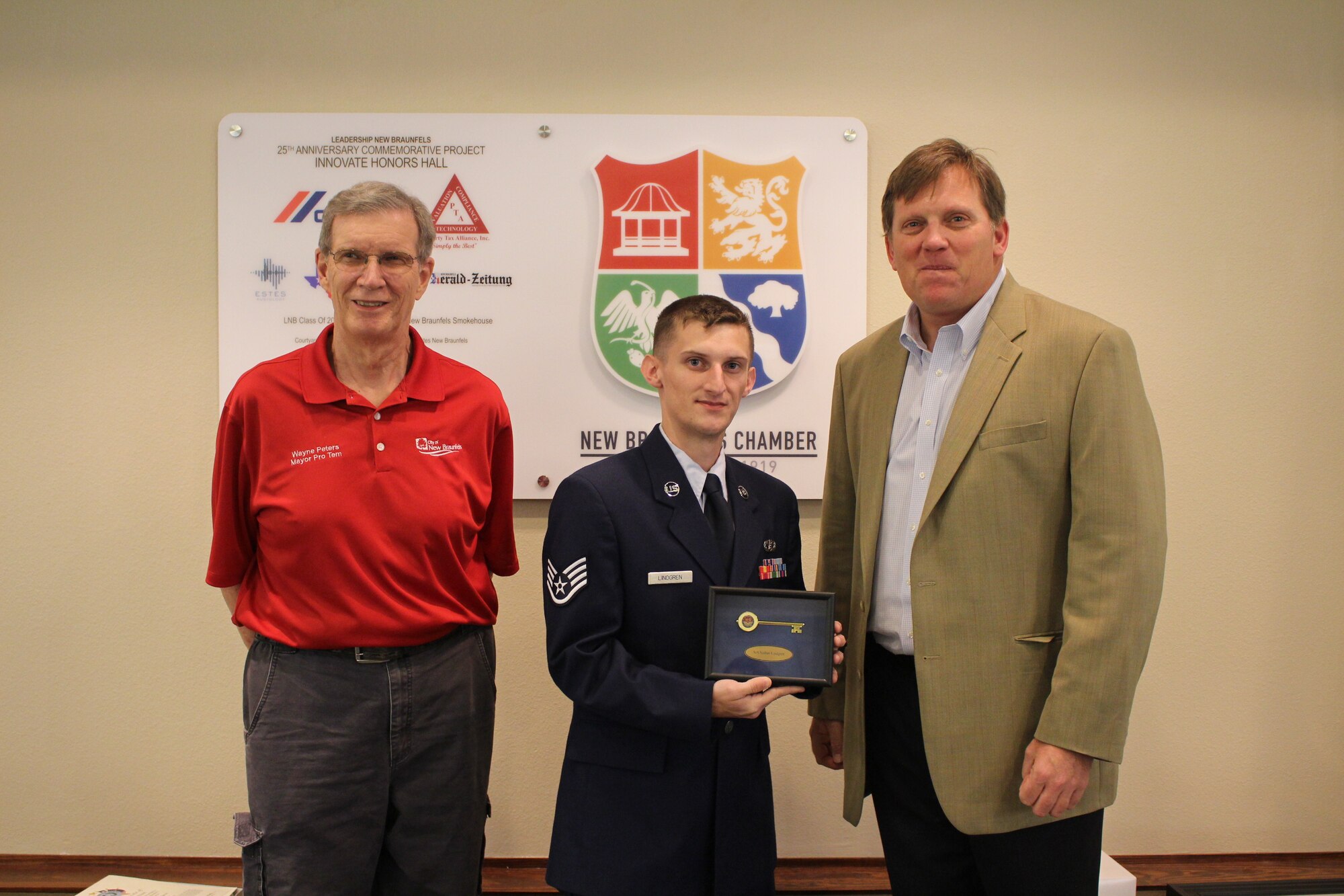Staff Sgt. Nathan Lindgren, 502 Civil Engineer Squadron firefighter, receives the key to the city from New Braunfels Mayor Pro Tem Wayne Peters, left, and Mayor Barron Casteel during a ceremony on May 14 that honored Lindgren as the New Braunfels Chamber of Commerce Airman of the Quarter.