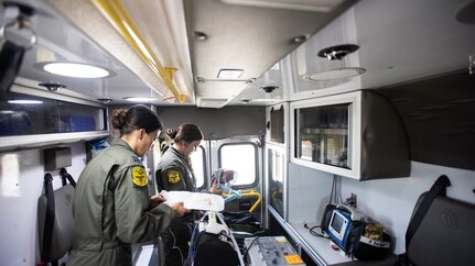 Capt. Nicole Lieb, 59th Medical Wing critical care air transport team nurse, and Senior Airman Analiese Heitkamp, CCATT respiratory therapist, prepare a litter to recieve 7-month-old patient, Nakoa Crawford, during a transfer to Balboa Naval Medical Center, San Diego, June 7, 2019. The teams operate a flying intensive care unit to transfer critically ill or injured patients to a hospital that can provide the elevated or specialized care they need.