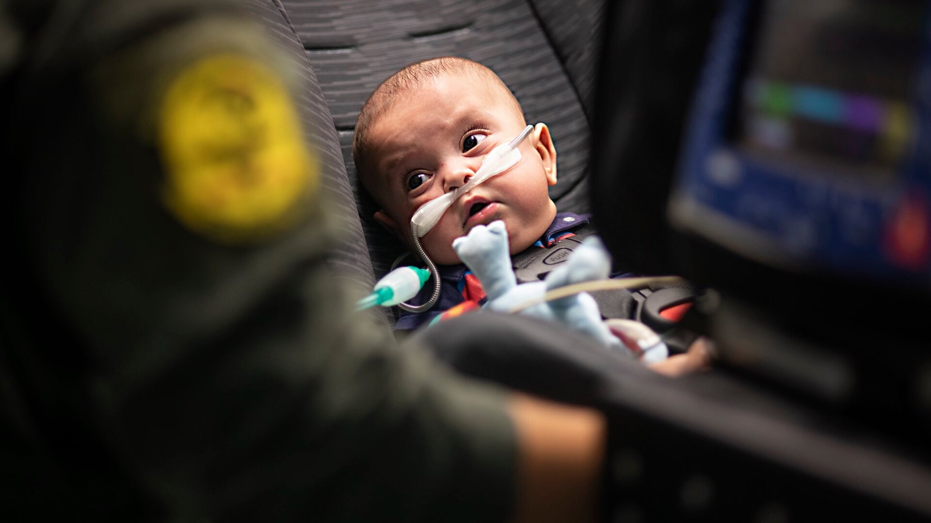 Nakoa Crawford, the 7-month-old son of U.S. Navy Petty Officer 2nd Class Daniel and Kaitlyn Crawford, looks up at Capt. Nicole Lieb, 59th Medical Wing critical care air transport nurse, as she prepares him to leave the hospital for the first time June 7, 2019 in Dallas. Nakoa was transported in a flying intensive care unit aboard a C-130 Hercules to a hospital closer to where his father is stationed in San Diego.