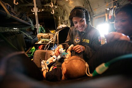 Capt. Nicole Leib and Maj. Mariana Lacuzong, 59th Medical Wing critical care air transport team nurses, play with 7-month-old patient, Nakoa Crawford, during the five-hour flight from Dallas to San Diego June 7, 2019. Comprised of a doctor, nurse and respiratory therapist, the team must pack everything the will need while airborne - echocardiogram, oxygen, blood, medicine and other tools of the trade.