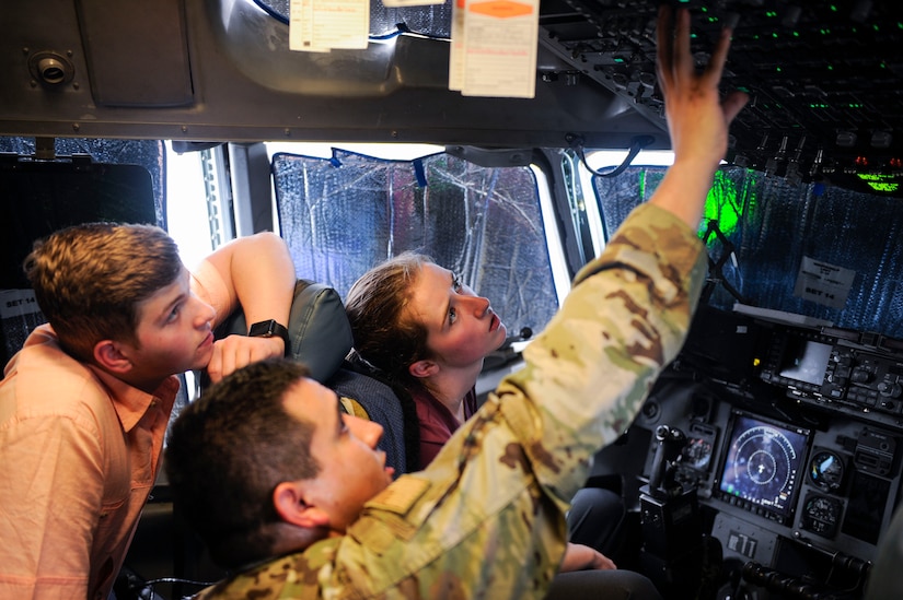 Senior Airman Ulises Zamora, a crew chief assigned to the 437th Aircraft Maintenance Squadron, explains some of the controls used on a C-17 Globemaster III to Aleric Stell, left, and Emma McBride, right, participants in the new Summer Intern Program, during a tour of Joint Base Charleston, S.C., June 10, 2019.