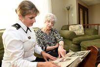 Brig. Gen. Kris A. Belanger, Commanding General, 85th U.S. Army Reserve Support Command looks at a scrapbook compiled by Aida Bonsonto of her husband’s Army service during World War II.