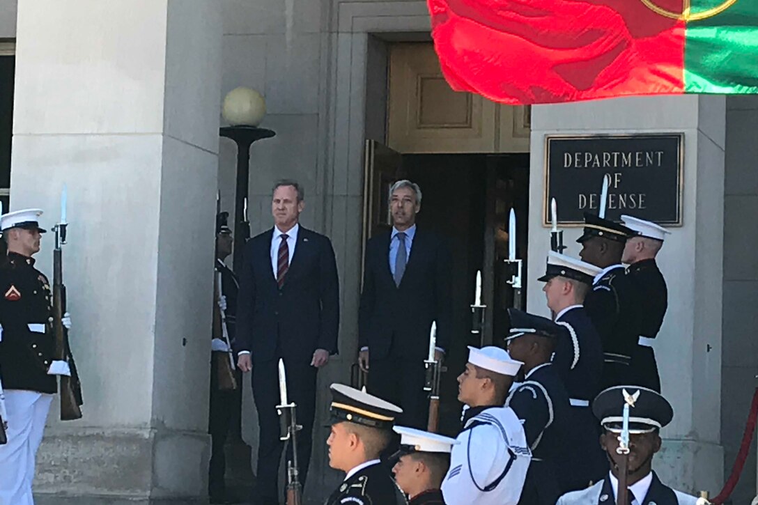 Two men stand at attention.