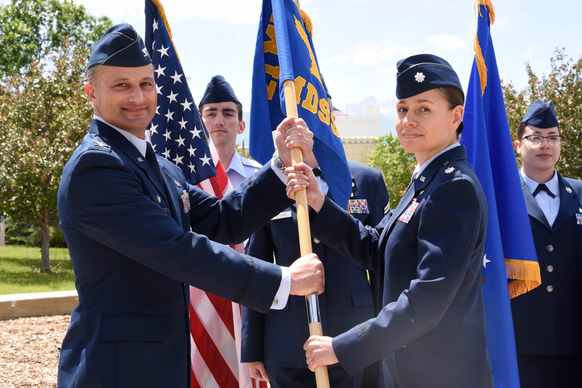 Col. Christopher Vaughn, 21st Medical Group commander, presents the guidon to Lt. Col. Lisa Guzman, 21st Medical Support Squadron commander, during a change of command ceremony, June 10, 2019 at Peterson Air Force Base, Colorado. The passing of the guidon represents a formal transfer of authority and responsibility from an outgoing commander to an incoming one. This ensures that the unit and its Airmen are never without leadership.  (U.S. Air Force photo by Staff Sgt. Alexandra M. Longfellow)