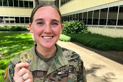Spc. Kayla Adkins, 384th Military Police Company and Greenwood, Ind., native, is all smiles as she proudly displays a commander’s challenge coin she received from Maj. Gen. David C. Coburn, U.S. Army Financial Management Command commanding general, during a ceremony celebrating both the 244th Army birthday and the 244th birthday of the Army Finance Corps at the Maj. Gen. Emmett J. Bean Federal Center in Indianapolis June 14, 2019. It is an Army tradition that the youngest Soldier available at an Army birthday celebration help the commander and sergeant major cut a cake, and Adkins was the youngest at 22 years old. (U.S. Army photo by Mark R. W. Orders-Woempner)