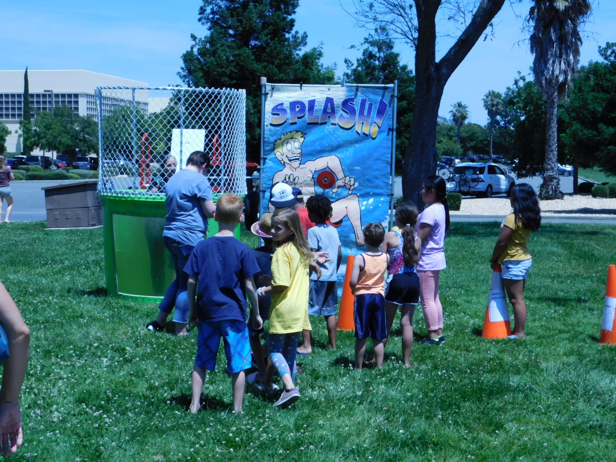 Lanora Cox, 60th Force Support Squadron librarian for the Mitchell Memorial Library, falls into a dunk tank during the Summer Reading Program kick-off event June 10, 2019, at Travis Air Force Base, California. The program, now in its second decade, promotes reading and learning across all ages. (U.S. Navy photo by Petty Officer 3rd Class Malcolm Kelley)