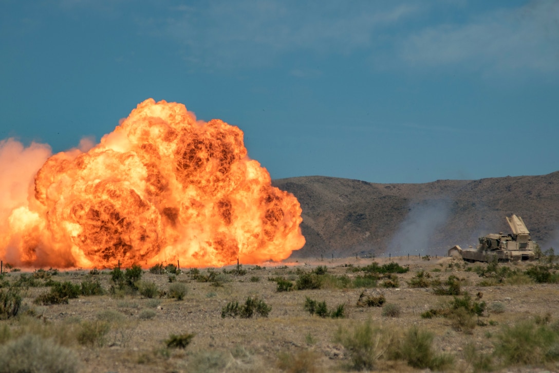 Soldiers in a tank set off a ball of fire.