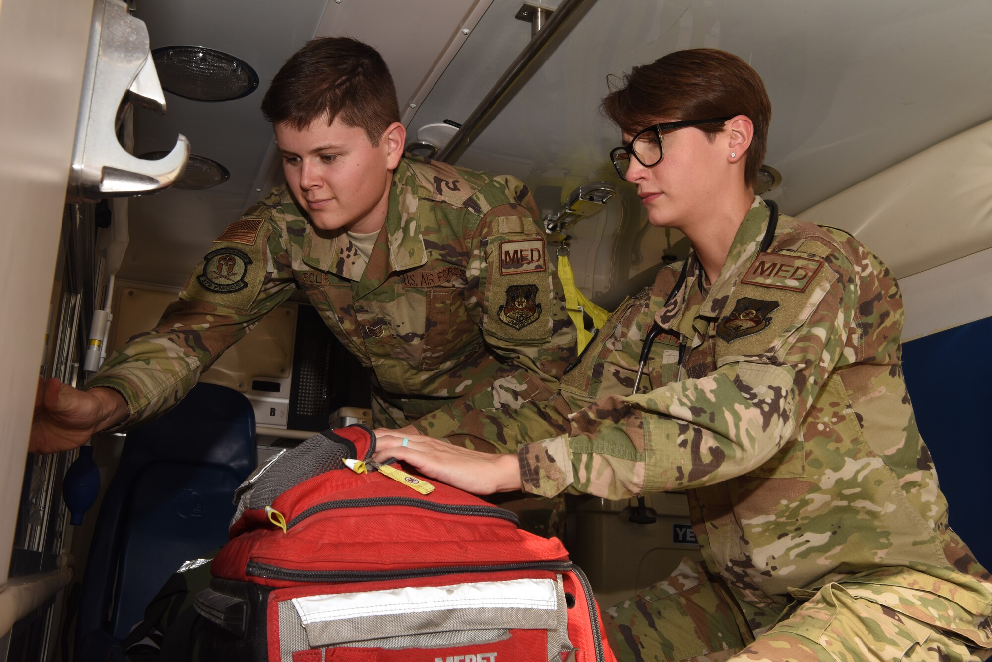 U.S Air Force Staff Sgt. Erik Polik and Staff Sgt. Berkeleigh Boe-Parreno, 379th Expeditionary Medical Operations Squadron medical technicians, inspect a first aid kit inside of an emergency vehicle at Al Udeid Air Base, Qatar, June 12, 2019. Technicians check medical first aid gear and kits so they can replace expired or damaged equipment. Having the proper equipment is vital in making sure AUAB members remain healthy to complete the mission. (U.S. Air Force photo by Staff Sergeant Ashley L. Gardner)