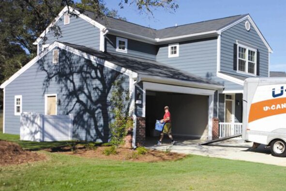 Two men inspect a ceiling vent in a home.