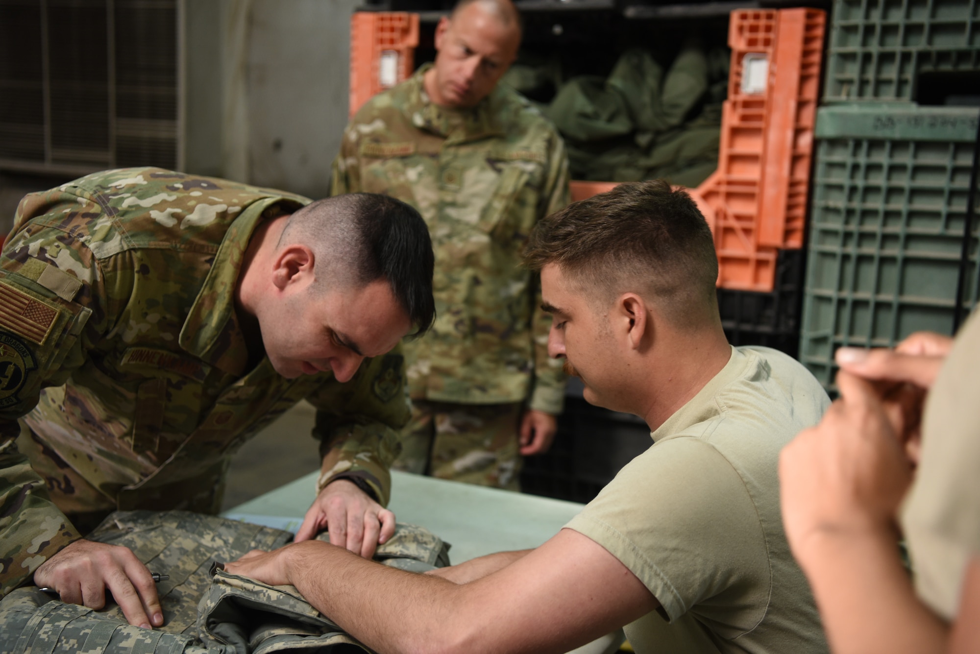 Members of the 380th Air Expeditionary Wing confirm the size of an Improved Outer Tactical Vest during an individual protective equipment issue exercise May 29, 2019, on Al Dhafra Air Base, United Arab Emirates.