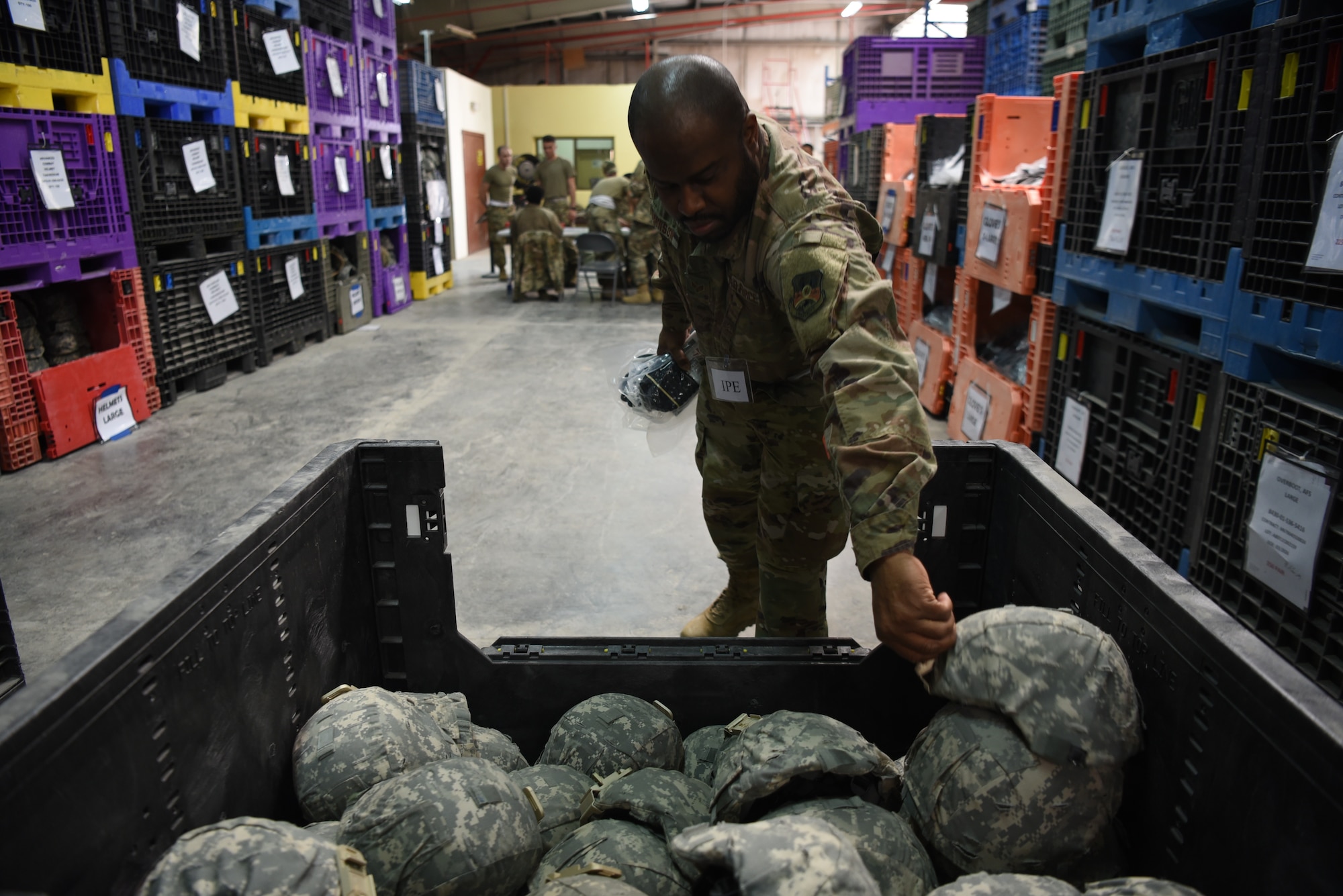 Senior Airman Tyrone Johnson, 380th Expeditionary Logistics Readiness Squadron materiel management, collects a helmet for a customer during an individual protective equipment issue exercise May 29, 2019, on Al Dhafra Air Base, United Arab Emirates.