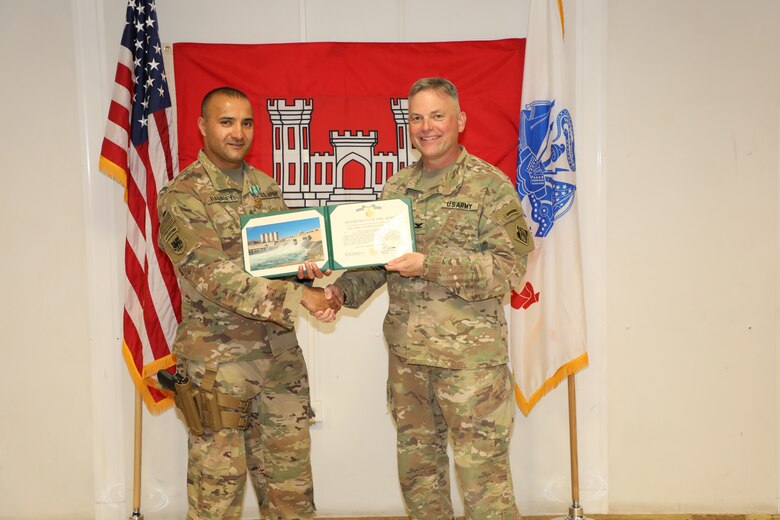 SFC Amit Ranadey (left) is presented with an Army Commendation Medal by U.S. Army Corps of Engineers Mosul Dam Task Force Commander Col. Philip Secrist during a ceremony held in Mosul, Iraq on June 14, 2019. Ranadey served in multiple roles on the MDTF. In addition to managing Task Force supply and logistics, he was instrumental in the Project’s Integration program training Iraqi Ministry of Water Resources personnel in up-to-date processes and technology related to warehouse management and supply accountability. Mosul Dam is a well-designed and well-constructed dam that is unique in that it requires continuous maintenance grouting operations due to the geology under the dam. USACE arrived at Mosul Dam in September 2016 to serve as “the Engineer” providing construction management, quality assurance, engineering and technical oversight and project management services in connection with a contract between Iraq and an Italian company for maintenance grouting and rehabilitation of the bottom outlet of the Mosul Dam.