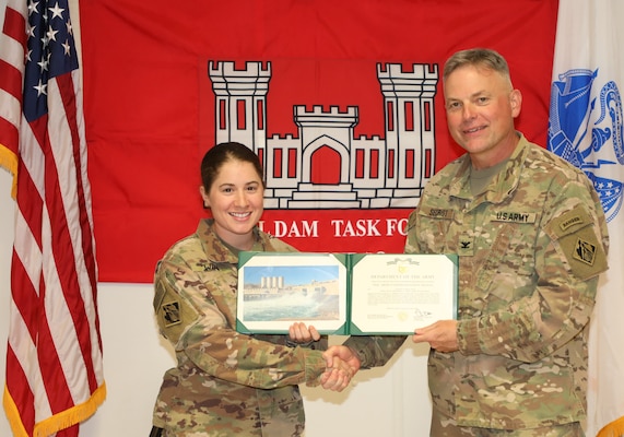 Capt. Laura Winn (left) is presented with an Army Commendation Medal by U.S. Army Corps of Engineers Mosul Dam Task Force Commander Col. Philip Secrist during a ceremony held in Mosul, Iraq on June 14, 2019. Winn served as a battle captain, requesting and monitoring air movements for the entire task force, maintaining accountability and force-protection procedures.Mosul Dam is a well-designed and well-constructed dam that is unique in that it requires continuous maintenance grouting operations due to the geology under the dam. USACE arrived at Mosul Dam in September 2016 to serve as “the Engineer” providing construction management, quality assurance, engineering and technical oversight and project management services in connection with a contract between Iraq and an Italian company for maintenance grouting and rehabilitation of the bottom outlet of the Mosul Dam.
