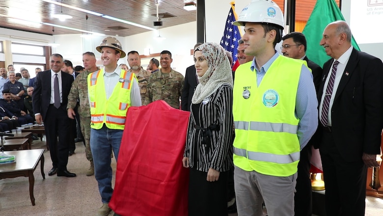 Workers from the U.S. Army Corps of Engineers, the Iraqi Ministry of Water Resources and Italian Company Trevi S.p.A. stand ready to unveil a new plaque that will hang at Mosul Dam, commemorating the 3-year partnership between the three countries of Iraq, the U.S. and Italy. The plaque was unveiled during a ceremony on June 15, 2019, at the Mosul Dam in Iraq. The Mosul Dam Project started in 2016 as a joint project among the Iraq Ministry of Water Resources, the U.S. Army Corps of Engineers, and Trevi in an effort to stabilize and repair the infrastructure of Mosul Dam. The dam, which is the largest in Iraq, and the fourth largest in the Middle East, supplies water, hydropower, irrigation and flood control to the region.
