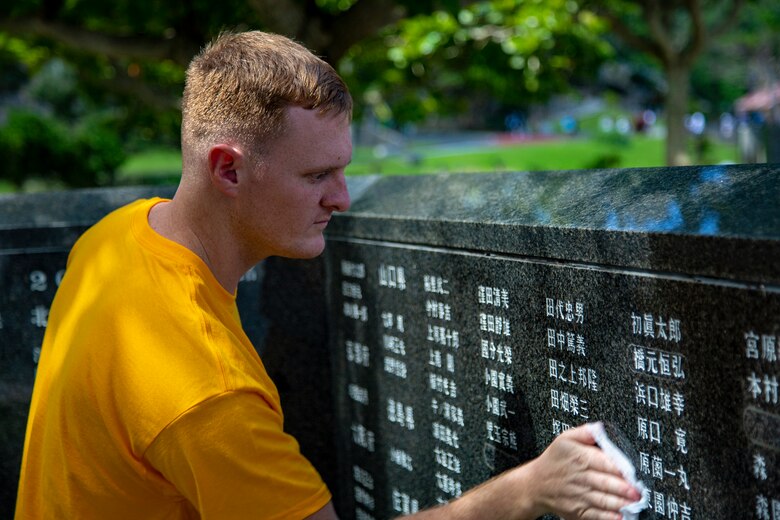 Spc. Mathew Gunter, a satellite maintainer with 78 Signal Battalion, wipes a memorial wall during a cleanup June 15 at Peace Memorial Park, Okinawa, Japan. The cleanup was done in preparation for Okinawa Memorial day, June 23, where many families come to Peace Memorial Park to honor the fallen soldiers from the Battle of Okinawa. (U.S. Marine Corps photo by Lance Cpl. Nicole Rogge)