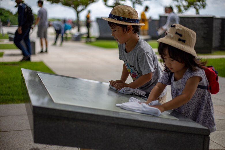 Children help wipe a monument wall during a cleanup June 15 at Peace Memorial Park, Okinawa, Japan. The cleanup was done in preparation for Okinawa Memorial day, June 23, where many families come to Peace Memorial Park to honor the fallen soldiers from the Battle of Okinawa. (U.S. Marine Corps photo by Lance Cpl. Nicole Rogge)