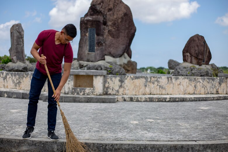 Pfc. John Xavier, a data systems administrator with 3rd Marine Logistics Group, sweeps around a memorial monument during a cleanup June 15 at Peace Memorial Park, Okinawa, Japan. The cleanup was done in preparation for Okinawa Memorial day, June 23, where many families come to Peace Memorial Park to honor the fallen soldiers from the Battle of Okinawa. (U.S. Marine Corps photo by Lance Cpl. Nicole Rogge)