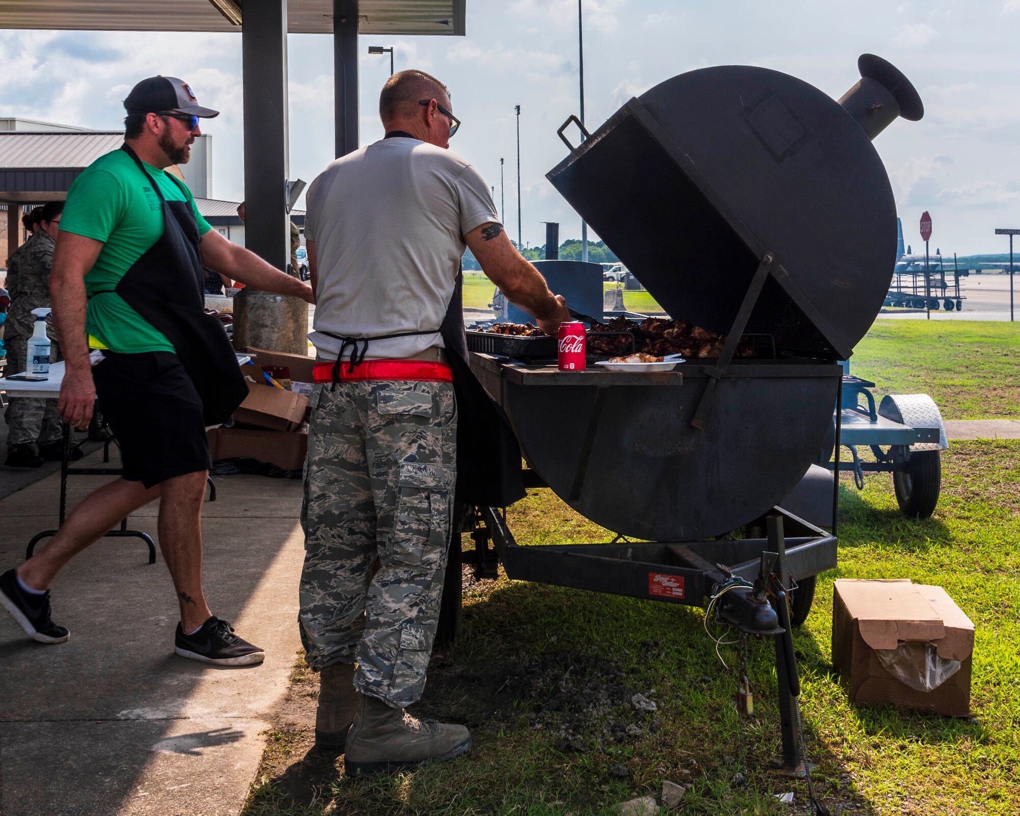 Chief Master Sgt. Ralph Babcock, 913th Maintenance Squadron superintendent, assists Donnie Ferneau, 913th Airlift Group honorary commander and renowned chef, with cooking barbeque for Reserve Citizen Airmen who recently returned from a deployment on May 20, 2019 at Little Rock Air Force Base, Ark.