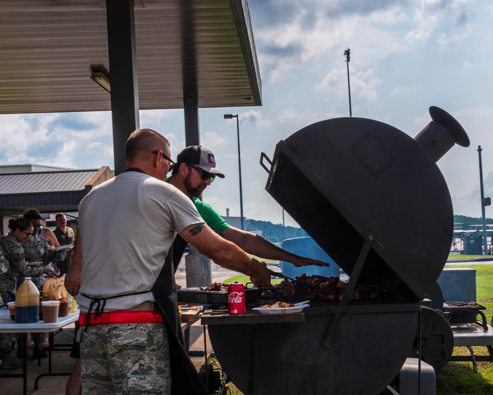Chief Master Sgt. Ralph Babcock, 913th Maintenance Squadron superintendent, assists Donnie Ferneau, 913th Airlift Group honorary commander and renowned chef, with cooking barbeque for Reserve Citizen Airmen who recently returned from a deployment on May 20, 2019 at Little Rock Air Force Base, Ark.