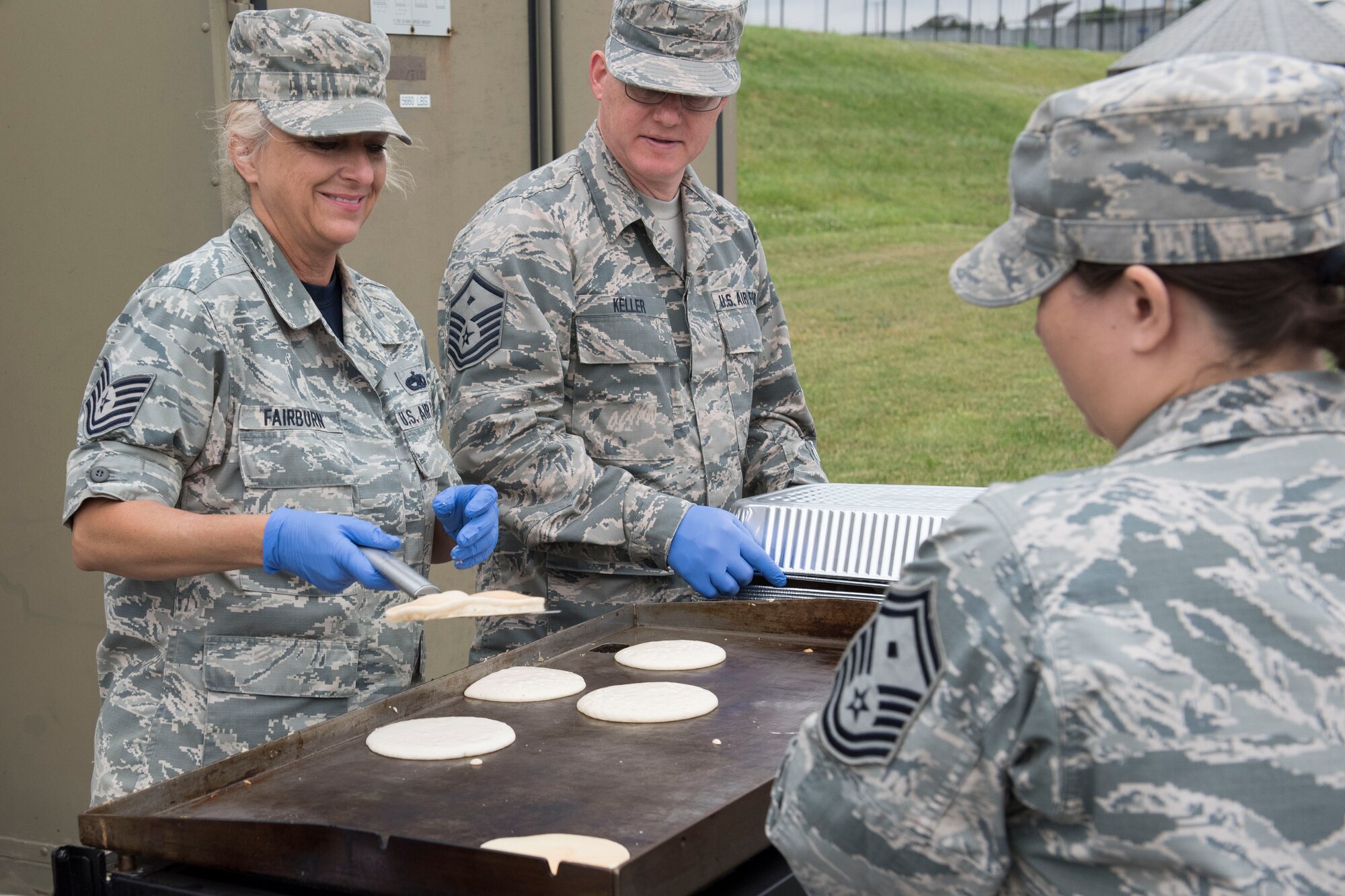 Tech. Sgt. Shannon Fairburn and Master Sgt. James Keller, members of the 167th Airlift Wing, serve pancakes outside of building 309 at the 167th Airlift Wing, June 6, 2019. The pancake breakfast was sponsored and planned by the First Sergeant Council. Approximately 300 Airmen enjoyed the pancakes and about $200 was raised in donations that the council plans to use towards different sponsorships. (U.S. Air National Guard photo by Tech. Sgt. Michael Dickson)