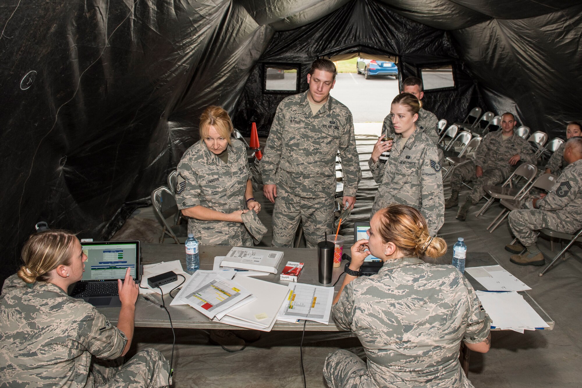 Airmen check in for their physical health assessment in a tent set up outside of the medical clinic as part of a new process tested by the 167th Medical Group, June 7, 2019. Check-in was moved outside to free space inside the building allowing more space to be used for exams and lab space. (U.S. Air National Guard photo by Tech. Sgt. Michael Dickson)