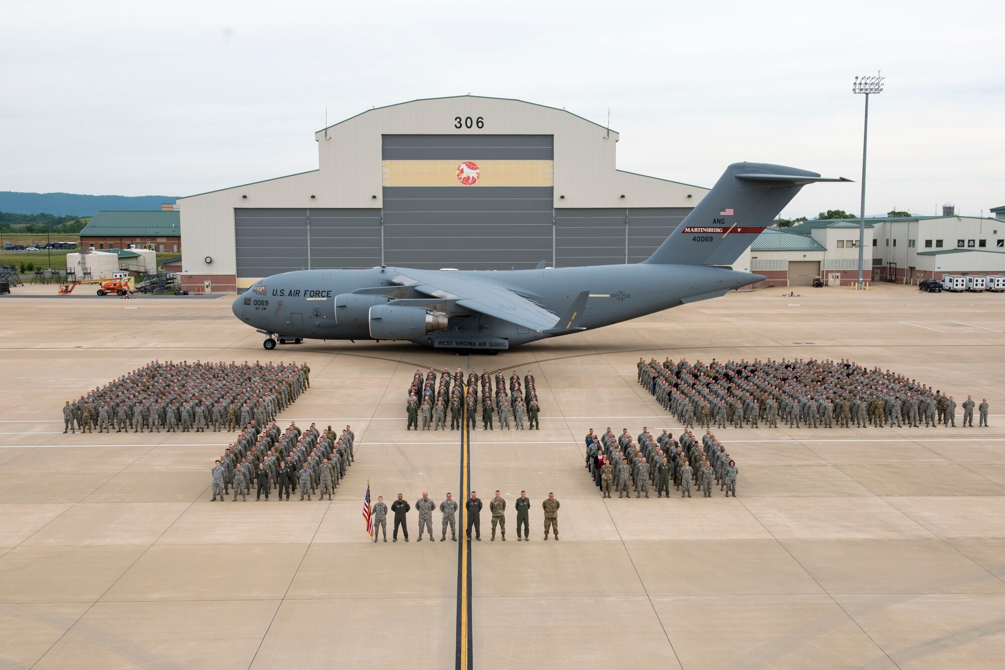 The 167th Airlift Wing stands in formation on the flightline in front of an aircraft hanger at the 167th AW in Martinsburg, W.Va., June 8, 2019. The wing photo was coordinated as part of the unit's extended training assembly. (U.S. Air National Guard photo by Tech. Sgt. Michael Dickson)