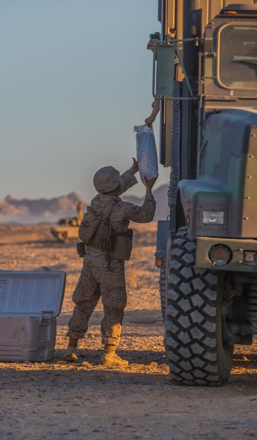A Marine with Engineer Company, Combat Logistics Battalion 23, 4th Marine Logistics Group, loads ice before a mechanized assault course during Integrated Training Exercise 4-19 at Marine Corps Air Ground Combat Center, Twentynine Palms, Calif., June 12, 2019. Today’s Marine Reserve is a critical component of the Marine Corps’ Total Force, and training like ITX helps ensure Reserve units combat effectiveness and proficiency for world-wide deployment. (U.S. Marine Corps photo by Lance Cpl. Preston L. Morris)