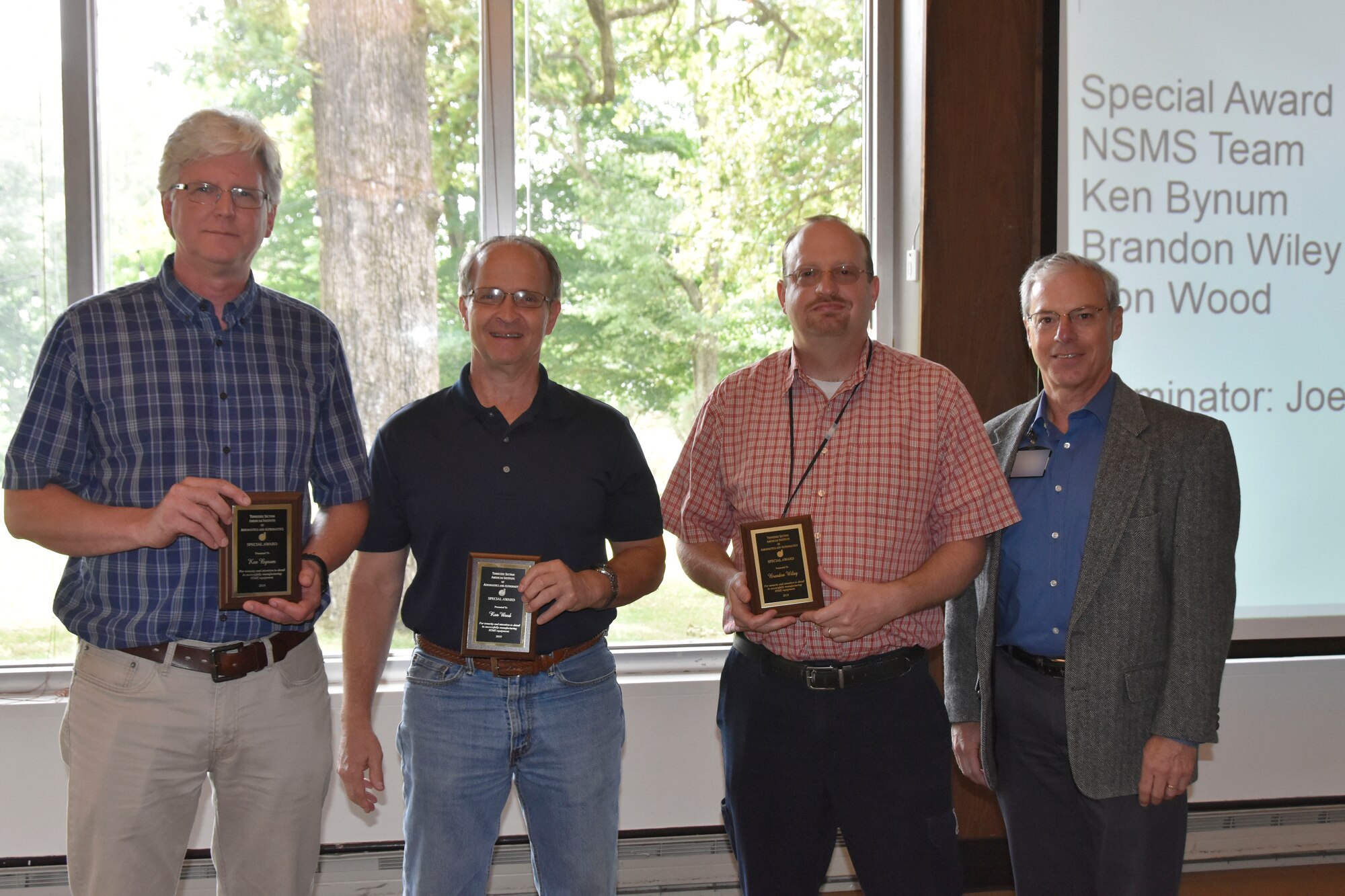 Members of the Non-interference Stress Measurement System Team accept an AIAA Special Award during the AIAA Annual Awards Luncheon May 30 at the Arnold Lakeside Center. Pictured from left are NSMS Team members Ken Bynum, Ron Wood and Brandon Wiley. The team received recognition for its tenacity and detailed work in the manufacture of NSMS equipment for the Air Force Research Laboratory. Also pictured is Joe Wehrmeyer, who nominated the team for the award. (U.S. Air Force photo by Bradley Hicks) (This image was altered by obscuring badges for security purposes)
