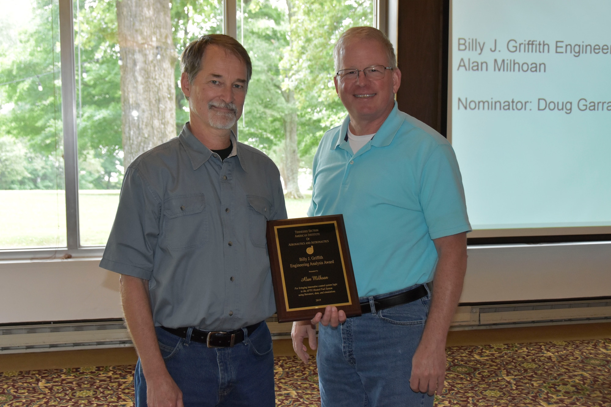 Alan Milhoan, left, receives the Billy J. Griffith Engineering Analysis Award during the AIAA Annual Awards Luncheon May 30 at the Arnold Lakeside Center. Milhoan received the award for bringing innovative control system logic to the Aerodynamic and Propulsion Test Unit through literature, data and simulations. Also pictured is Doug Garrard, who nominated Milhoan for the award. (U.S. Air Force photo by Bradley Hicks)