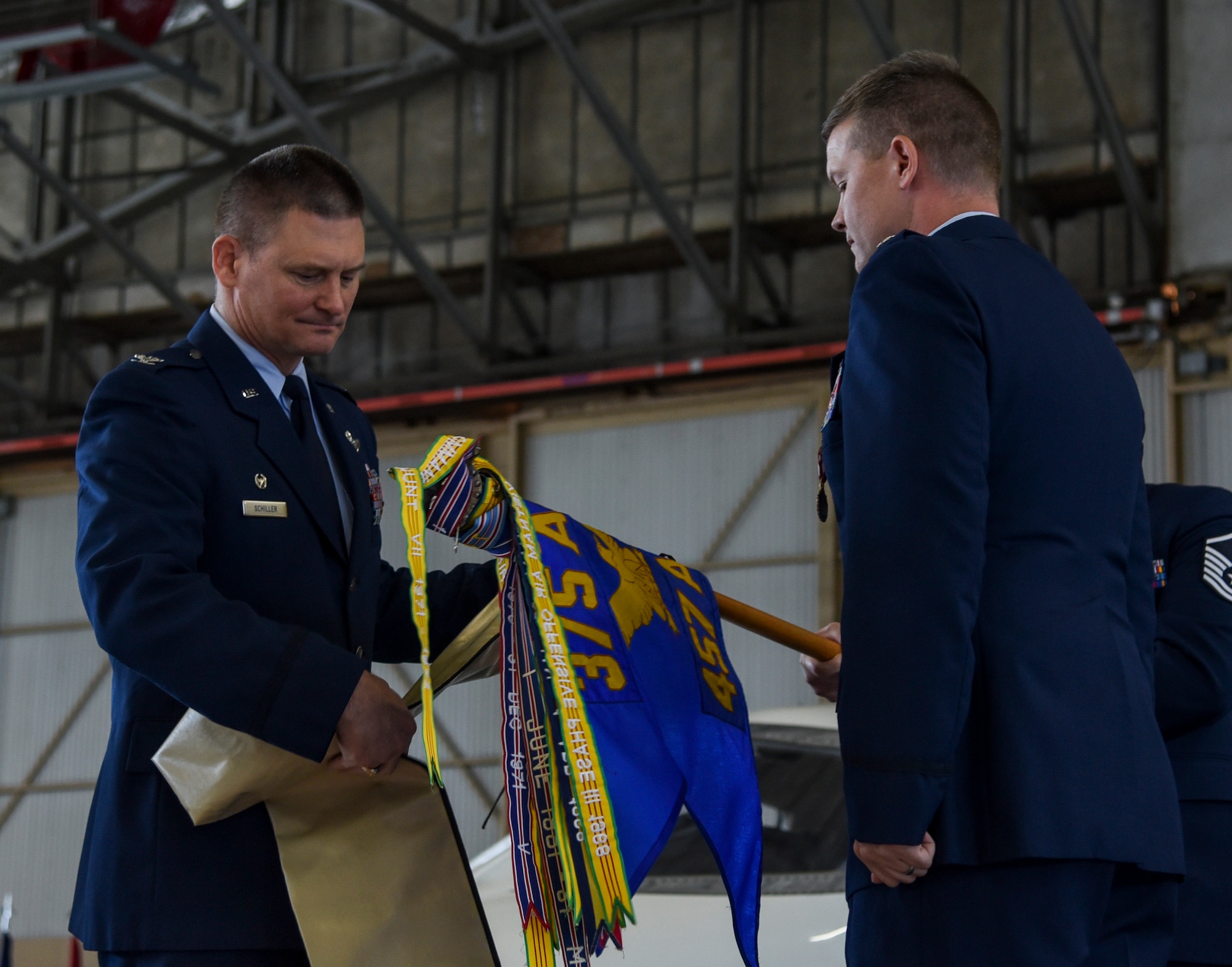 Col. Kevin Schiller, 375th Operations Group commander, and Lt. Col. Royce Lippert, 457th Airlift Squadron commander, furl the 457th flag during an inactivation ceremony at Joint Base Andrews, Maryland, June 14, 2019. The 457th AS was first stood up as the 457th Heavy Bombardment Squadron on July 1, 1942, and was responsible for training stateside aircrews in the B-17 Flying Fortress and B-24 Liberator. (U.S. Air Force photo by Senior Airman Chad Gorecki)