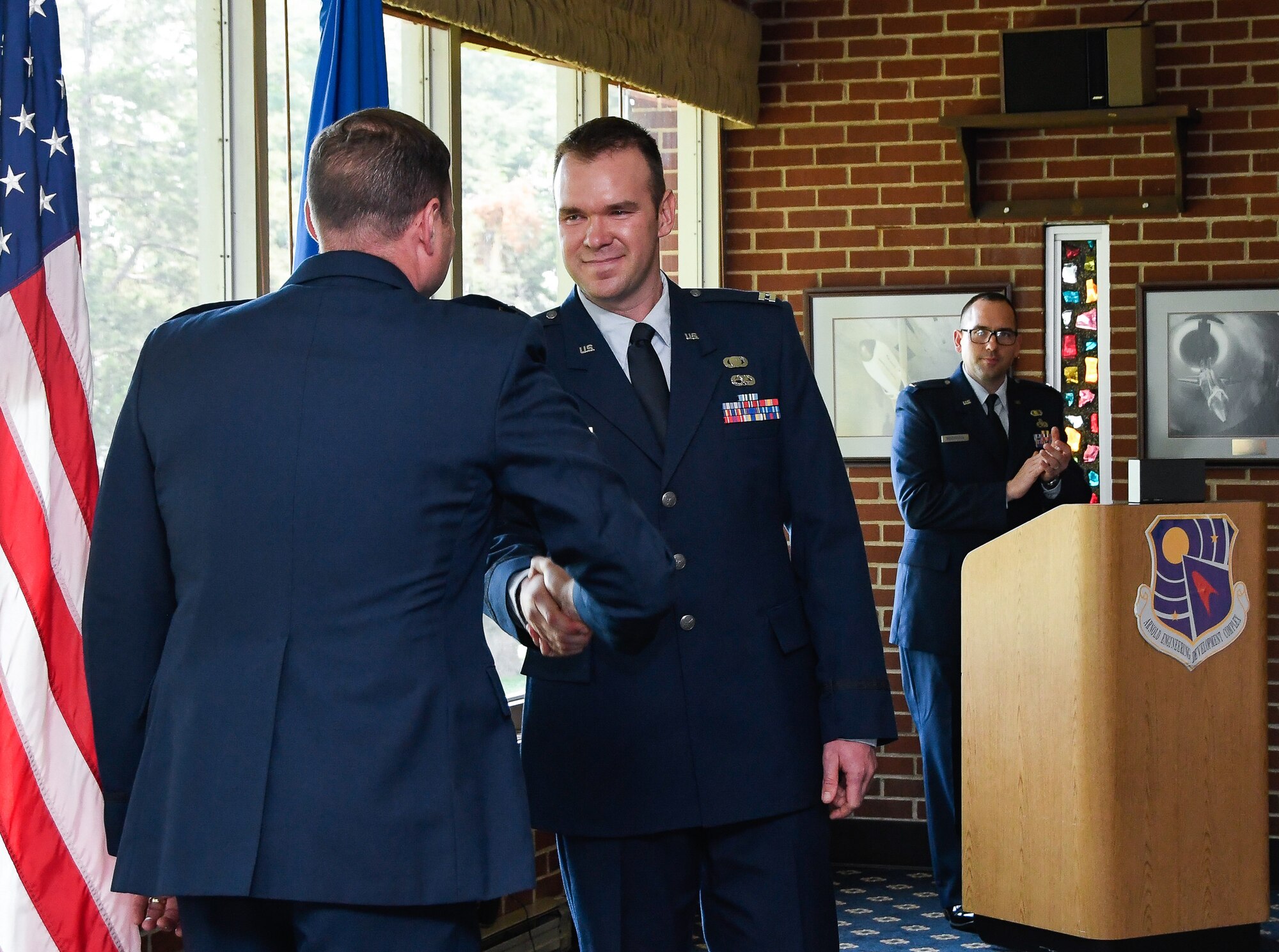 Capt. Johnathan Gutierrez, center, shakes hands with Flight Systems Combined Test Force Director Lt. Col. David Hoffman, during Gutierrez's promotion cermeony,  May 23 at Arnold Lakeside Center on Arnold Air Force Base. (U.S. Air Force photo by Jill Pickett)