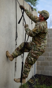 Master Sgt. Travis Mooney, 66th Training Squadron, Det. 3 cadre, demonstrates how to use survival items or debris to safely scale a wall in an isolation or evasion-type environment, June 3. Survival, evasion, resistance and escape cadre from are responsible for both the four-day Evasion and Conduct After Capture Course and the 15-day SERE Specialist Training Orientation Course at Joint Base San Antonio-Lackland. ECAC was the first stop for recruiters from the 330th RCS who travelled from across the United States to attend this biannual squadron training intended to immerse recruiters into SERE training in order for them to be better able to recruit Air Force SERE candidates.
