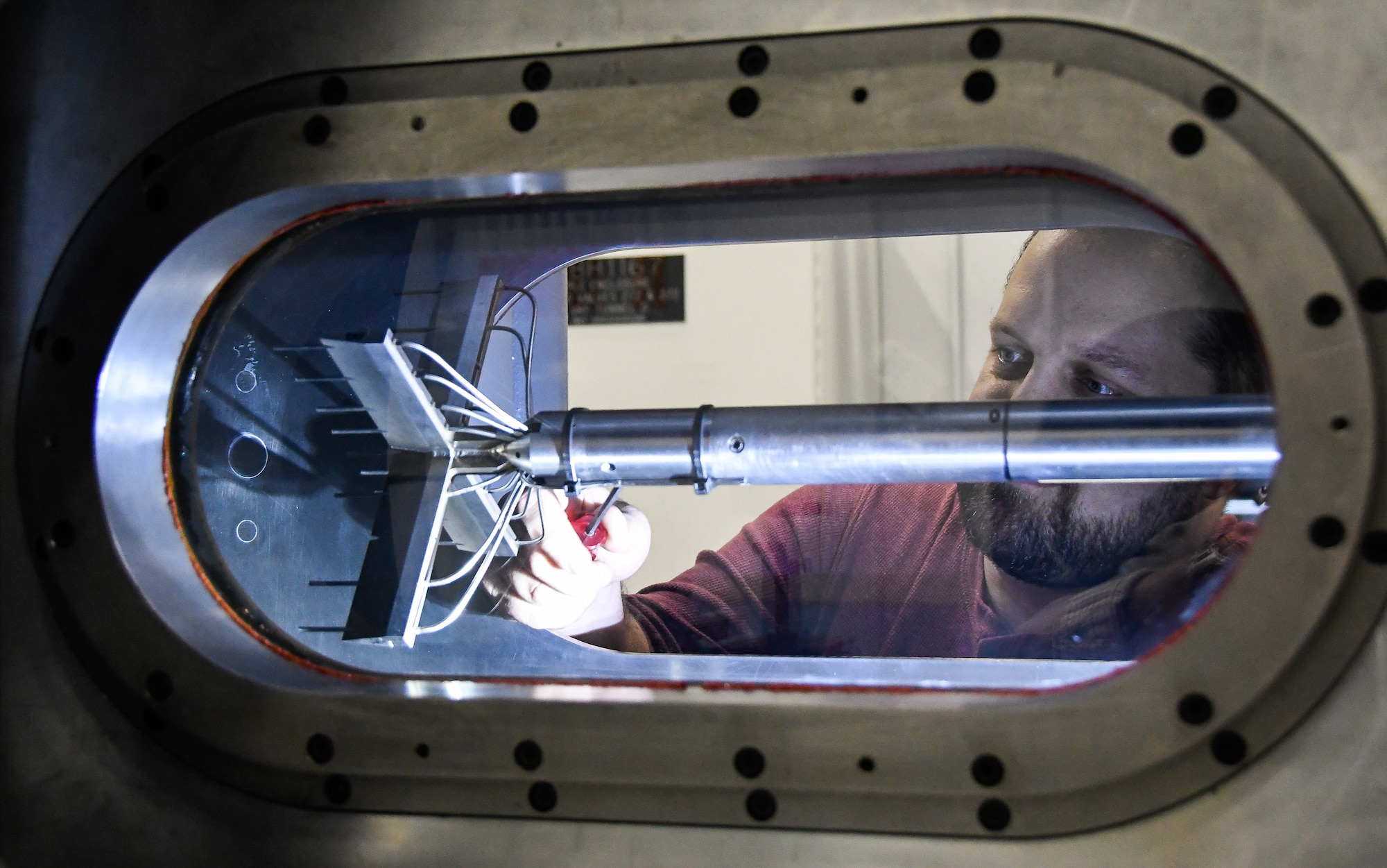 Dr. Jerrod Hofferth, von Kármán Gas Dynamics Facility Wind Tunnel D lead engineer, works on a freestream characterization rake, used to determine Mach Number Uniformity, positioned in the Tunnel D test cell June 5 at Arnold Air Force Base. The tunnel was reactivated earlier this year and is operated by the Air Force Research Laboratory High Speed Experimentation Branch. (U.S. Air Force photo by Jill Pickett)