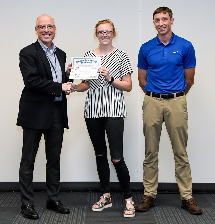 Dr. Rich Tighe, left, general manager of the Test Operations and Sustainment contractor at Arnold Air Force Base, presents a certificate to Kayden Fletcher recognizing her as one of the 2019 Bechtel Global Scholars during a meeting June 7 at Arnold. Also pictured is Kayden's father Jeremy Fletcher, a Propulsion Wind Tunnel controls engineer at Arnold. Kayden will receive a $3,000 scholarship funded by the Bechtel Group Foundation for her first year of study at an accredited institution. (U.S. Air Force photo by Jill Pickett) (This image has been altered by obscuring a badge for security purposes.)