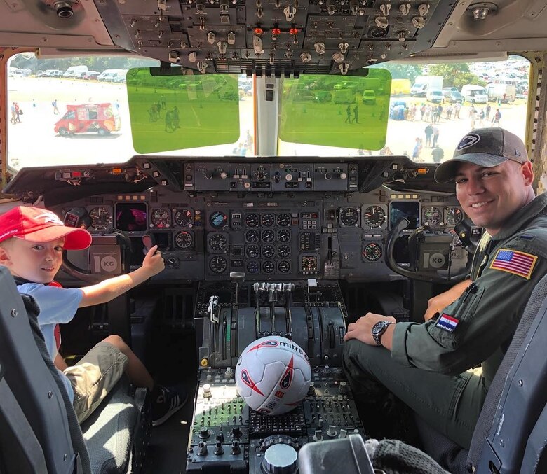 1st Lt. Alexandro Retamozo, 78th Air Refueling Squadron pilot, sits in the cockpit of a KC-10 Extender with a child touring the jet at the Royal International Air Tattoo at RAF Fairford, July 14, 2018. Joint Base McGuire-Dix-Lakehurst participated in RIAT which celebrated 100 years of the Royal Air Force, making it the world's oldest independent air force. (Courtesy Photo)