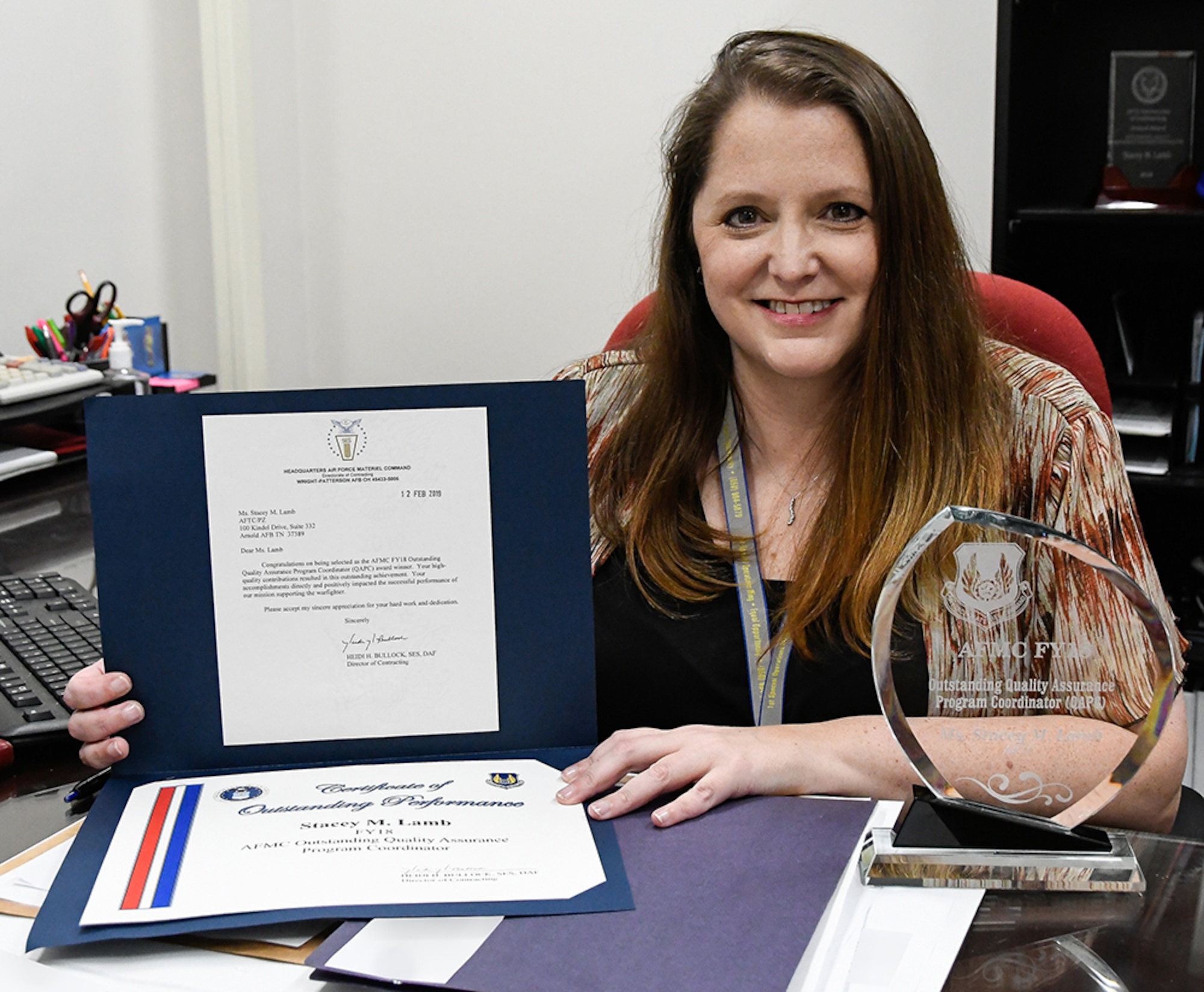 Stacey Lamb, AEDC Quality Assurance Program Coordinator and Small Business Specialist at Arnold Air Force Base, displays the award and certificate she received for being named the Air Force Materiel Command Outstanding Quality Assurance Program Coordinator for fiscal year 2018. (U.S. Air Force photo by Jill Pickett) (This image was altered by obscuring items for security purposes.)
