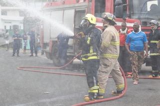 Members of the Saint Vincent and the Grenadines fire department work to put out simulated fire.