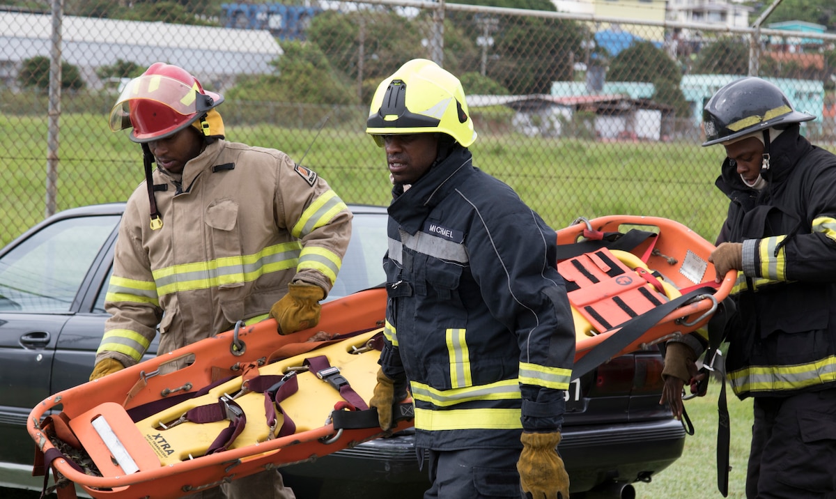 Three firemen with the Saint Vincent and the Grenadines fire department prepare to evacuate wounded in simulated training exercise during phase II of Tradewinds 2019